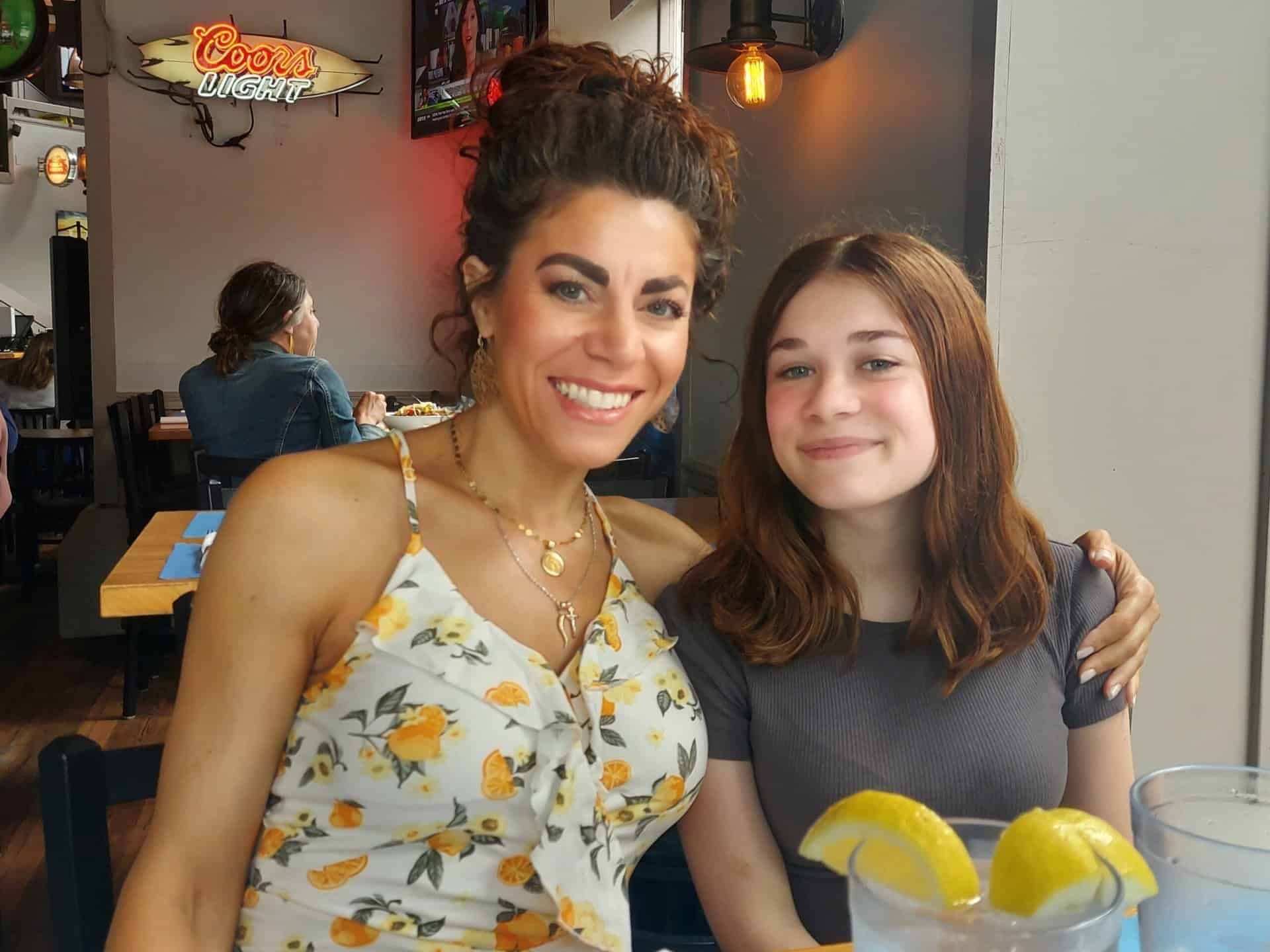 Woman and girl smiling at a restaurant table