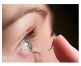 Woman putting contact lens on eye