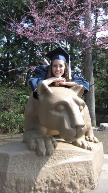 Girl in graduation cap and gown on the Penn State Nittany Lion Shrine