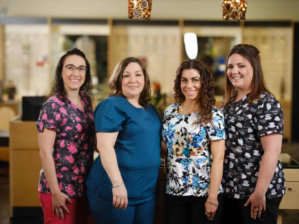 Four women in medical scrubs smiling