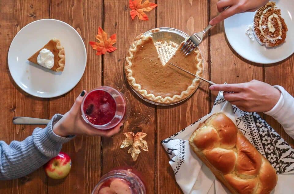 Pumpkin pie, bread, and drinks on a rustic wooden table