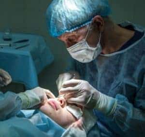 Man performing eye surgery on a woman