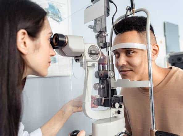 Eye doctor examining a man's eyes with a slit lamp