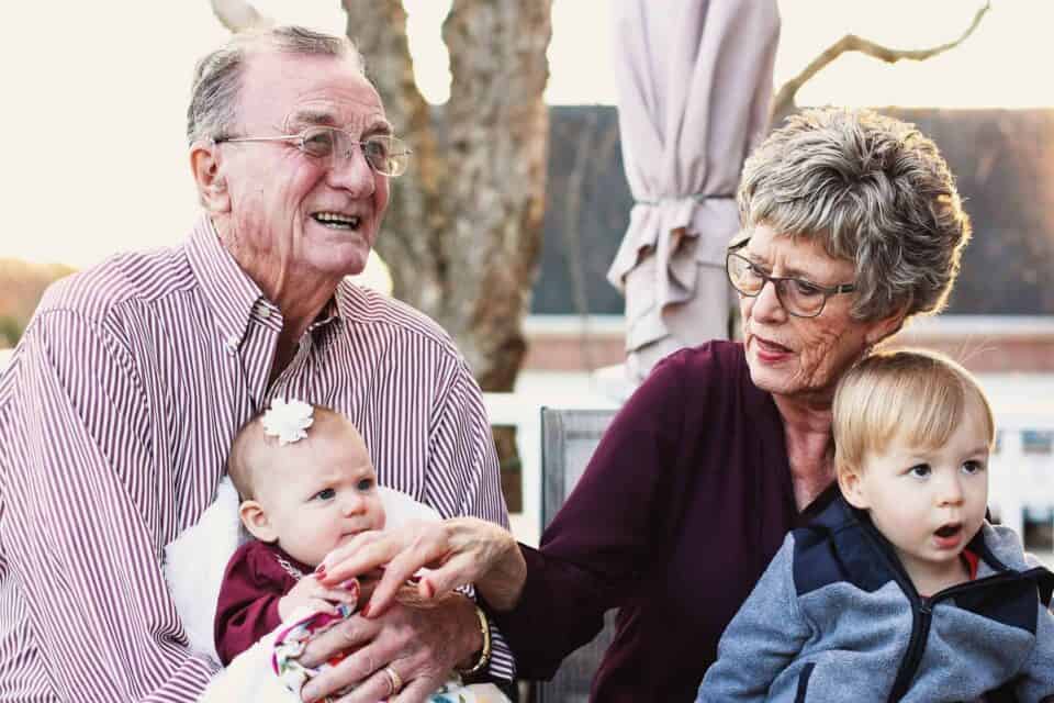 Elderly couple holding two children