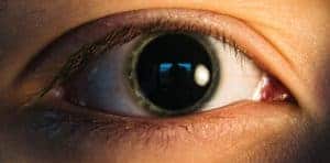 This is a person's eye with a green iris and very large, dilated pupil.
